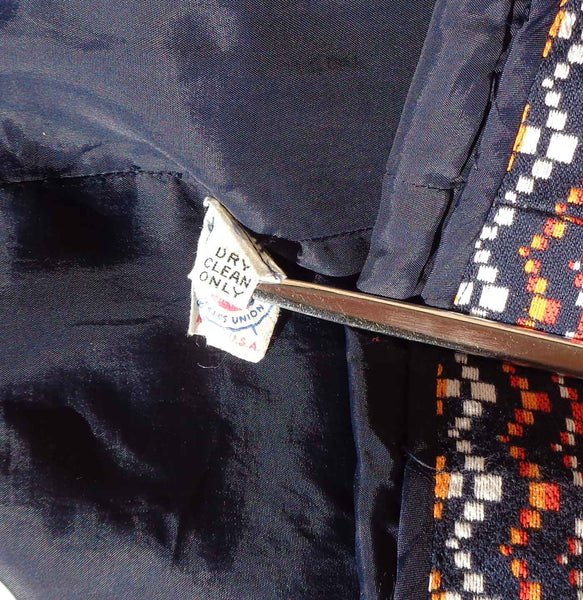 Close-up of a navy blue garment with a care label and colorful patterned fabric.